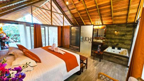 a bedroom with a bed and a bathroom with a tub at Suchipakari Amazon Eco -Lodge & Jungle Reserve in Puerto Misahuallí