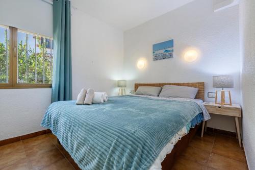 a bedroom with a bed with a blue blanket at Surf Bahia M in Montroig