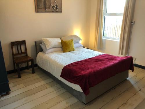 a bed in a bedroom with a chair and a window at Stylish flat in Chesterfield Peak District in Chesterfield