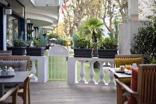 a restaurant with tables and chairs and potted plants at Juliana Hotel Cannes in Cannes