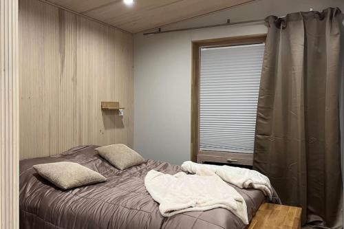 a bedroom with a bed and a window with a curtain at Villa Naali E in Kilpisjärvi