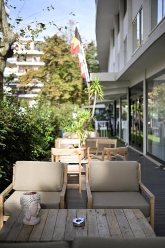 a patio with two chairs and a wooden table at Juliana Hotel Cannes in Cannes