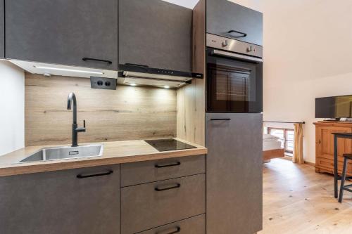 a kitchen with a sink and a stove top oven at Apartments am Schloss Mühldorf in Feldkirchen an der Donau