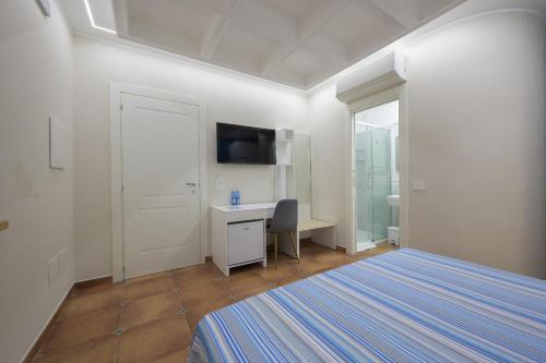 a bedroom with a bed and a desk and a tv at Morrone Inn in Marano Marchesato
