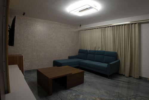 a living room with a blue couch and a table at Mystery Maze Resort and Spa in Wayanad