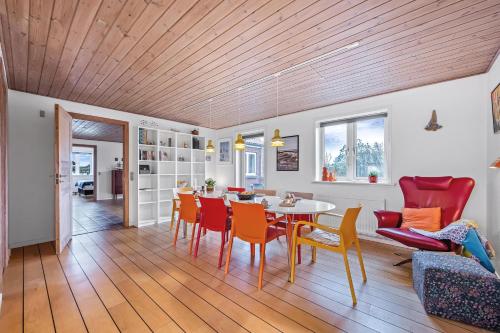 a dining room and living room with a table and chairs at Lovely Holiday House With 4 Rooms Close To The North Sea in Frøstrup