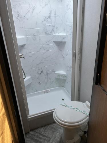 a white bathroom with a toilet and a shower at RV In Orlando No Local Guests in Orlando