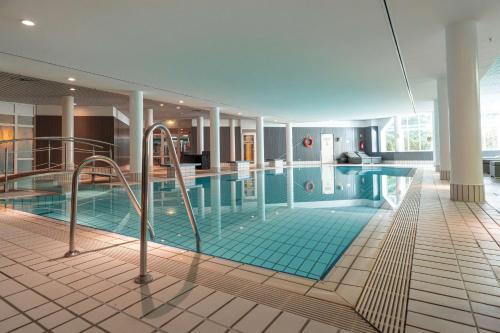 a large swimming pool in a large building at Radisson Blu Hotel Dortmund in Dortmund