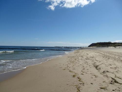 a beach with footprints in the sand and the ocean at Peenemünde, Seglerhafen_SB_Jolle 17 in Peenemünde