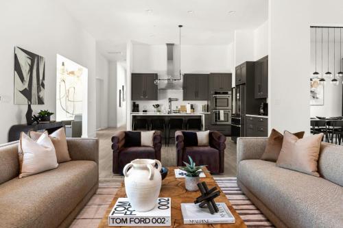 a living room with two couches and a kitchen at Designer Home with Hot Tub BBQ & Hill Views in Driftwood