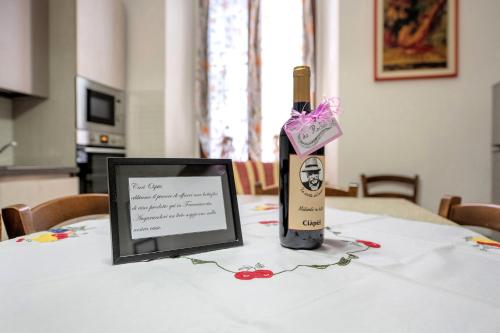 a bottle of wine and a picture on a table at Casa vacanze da rosa in Iseo