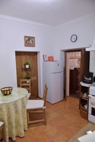 a kitchen with a table and a white refrigerator at Casa dos Avós in Évora Monte