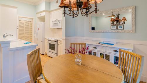 a kitchen with a wooden table with chairs and a sink at Coconut Plantation 1110-3 in Kapolei