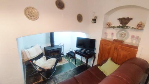a living room with a couch and a wood stove at Casa dos Avós in Évora Monte