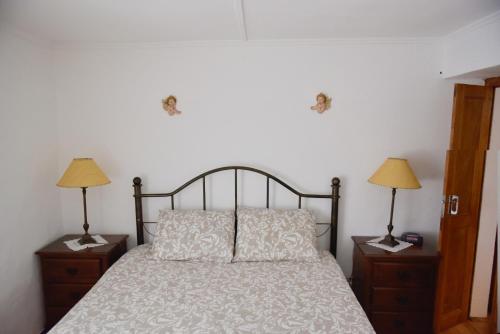 a bedroom with a bed and two lamps on night stands at Casa dos Avós in Évora Monte