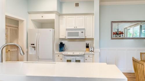 a kitchen with white cabinets and a white refrigerator at Coconut Plantation 1110-3 in Kapolei