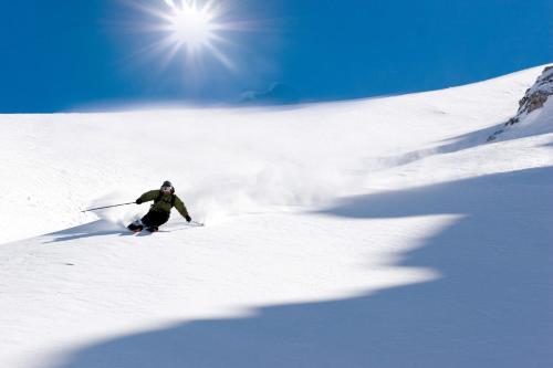 a person is skiing down a snow covered slope at Apartment Edith in Telfes im Stubai