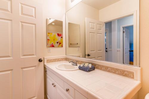a bathroom with a sink and a mirror at Coconut Plantation 1110-3 in Kapolei