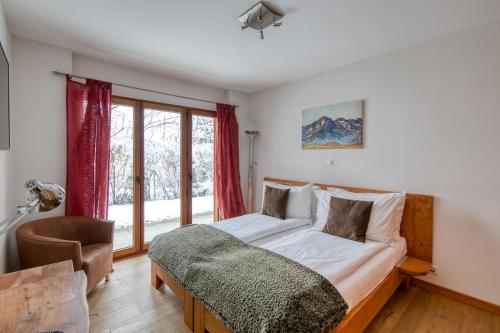 a bedroom with a bed and a window at Lodge 3 Nordic Bath & Garden in Champéry