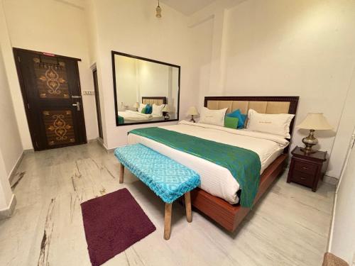 a bedroom with a large bed and a mirror at Hotel Nirvana Lakeside in Udaipur