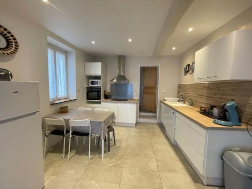 une cuisine avec une table et quelques chaises dans l'établissement Maison de Village, 3 chambres, fibre, à Dunes