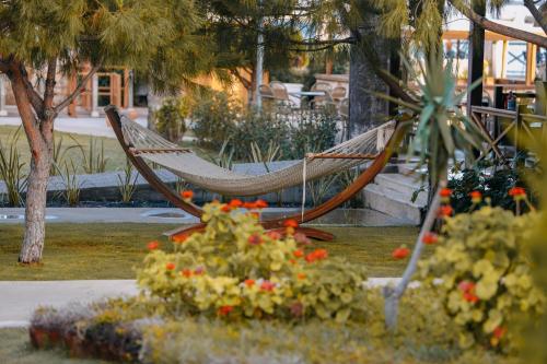a hammock in a park with flowers and plants at Prive Hotel Didim - Ultra All Inclusive in Didim