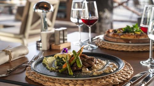 a table with a plate of food and wine glasses at Prive Hotel Didim - Ultra All Inclusive in Didim