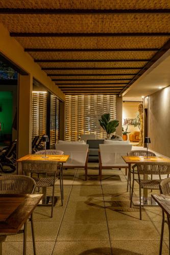 a restaurant with tables and chairs and a couch at Pousada Yamandu - Piscinas Aquecidas in Juquei