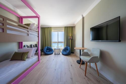a bedroom with a bunk bed with a flat screen tv at Prive Hotel Didim - Ultra All Inclusive in Didim