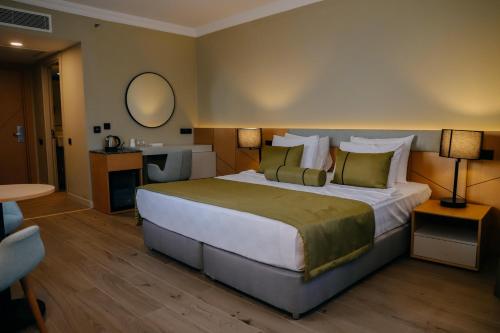a hotel room with a large bed and a mirror at Prive Hotel Didim - Ultra All Inclusive in Didim