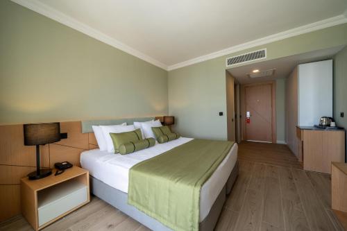 a hotel room with a large bed and a table at Prive Hotel Didim - Ultra All Inclusive in Didim