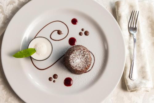 a white plate with a dessert on a table at AGRITURISMO RIPA DEL BOSCO in Capriolo