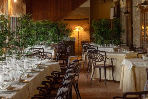 a dining room with tables and chairs and plants at AGRITURISMO RIPA DEL BOSCO in Capriolo