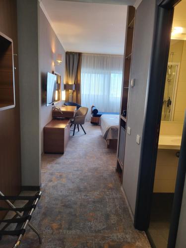 a hotel room with a bedroom and a bed at Wyndham Cluj in Cluj-Napoca