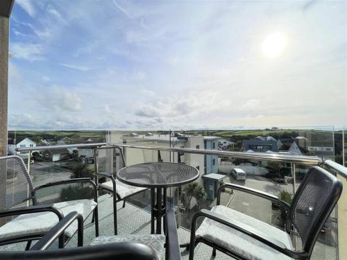 a balcony with a table and chairs and a view at Modern Apartment nr Fistral Beach Private Parking in Newquay