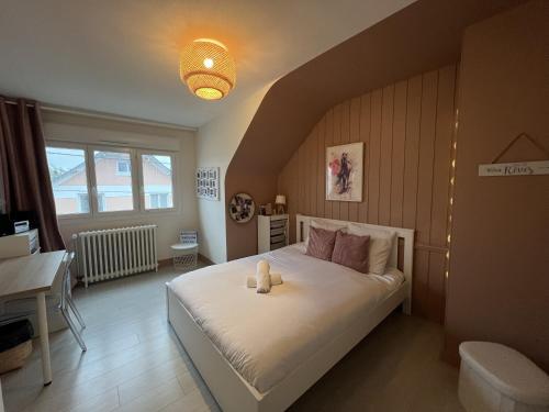 ein Schlafzimmer mit einem Bett, auf dem ein Teddybär liegt in der Unterkunft La Maison des Rêves - 8 pers - Centre - Rêve au Mans in Le Mans