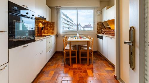 une cuisine avec une table et des chaises et une fenêtre dans l'établissement L'Edito - Centre Ville - Gare - Balcon - 6prs, à Dijon