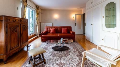 un salon avec un canapé rouge et une table dans l'établissement L'Edito - Centre Ville - Gare - Balcon - 6prs, à Dijon