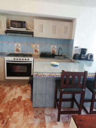 a kitchen with a stove and a counter top at Condominio Privado Villas Marlin Zona Hotelera Cancun in Cancún