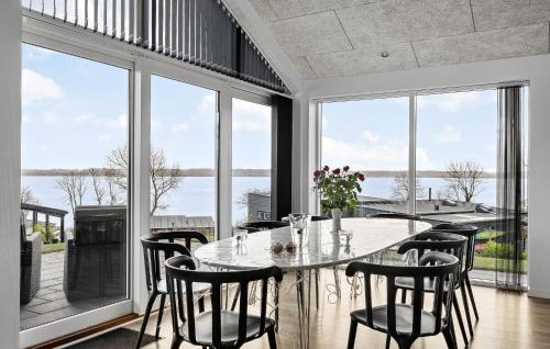 a dining room with a table and chairs and windows at 3 Bedroom Stunning Home In Aabenraa in Aabenraa