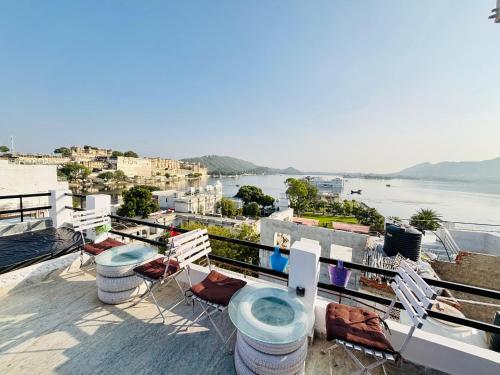 a balcony with chairs and a view of the water at Hotel Nirvana Lakeside in Udaipur