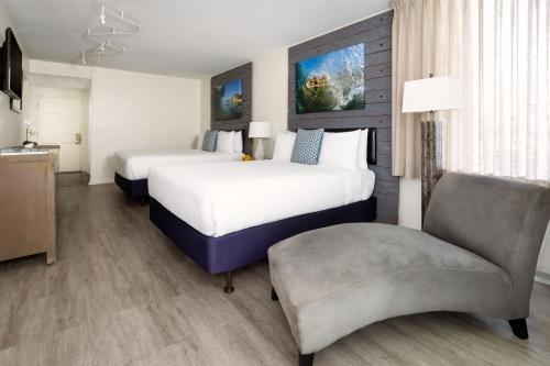 a hotel room with two beds and a chair at Pacific Edge Hotel in Laguna Beach