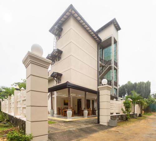 a large white building with a balcony at Villa Serenita Weligama in Weligama