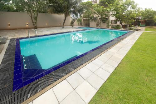 a swimming pool in a yard with blue tiles at Villa Serenita Weligama in Weligama