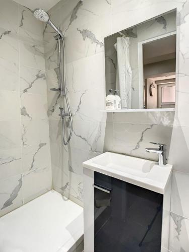 une salle de bain blanche avec un lavabo et une douche dans l'établissement T3 of aix, à Aix-en-Provence