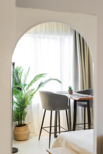 a dining room with a table and chairs and a window at Marabou Unique Stay in Thessaloniki
