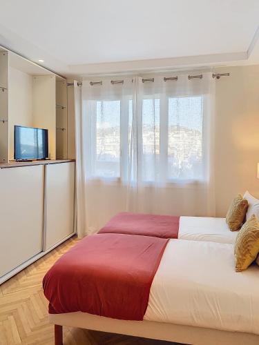 une chambre avec un grand lit et une télévision dans l'établissement 3p Quai St Pierre - 348L Alexa, à Cannes