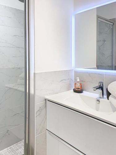 une salle de bain blanche avec un lavabo et une douche dans l'établissement 3p Quai St Pierre - 348L Alexa, à Cannes