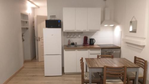 une cuisine avec une table et un réfrigérateur blanc dans l'établissement Excellent Studio au cœur historique de Fréjus, à Fréjus