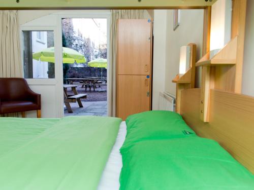 a bedroom with a bed and a patio with an umbrella at YHA London Earl's Court in London